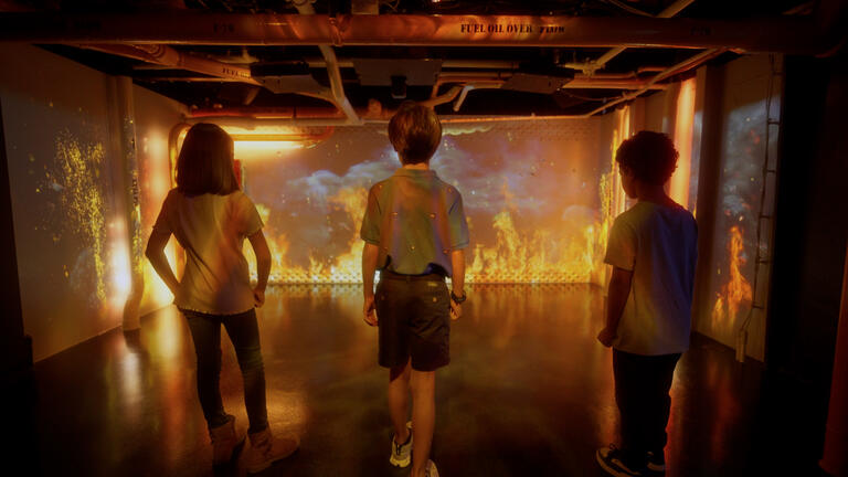 Three children exploring USS Midway exhibition