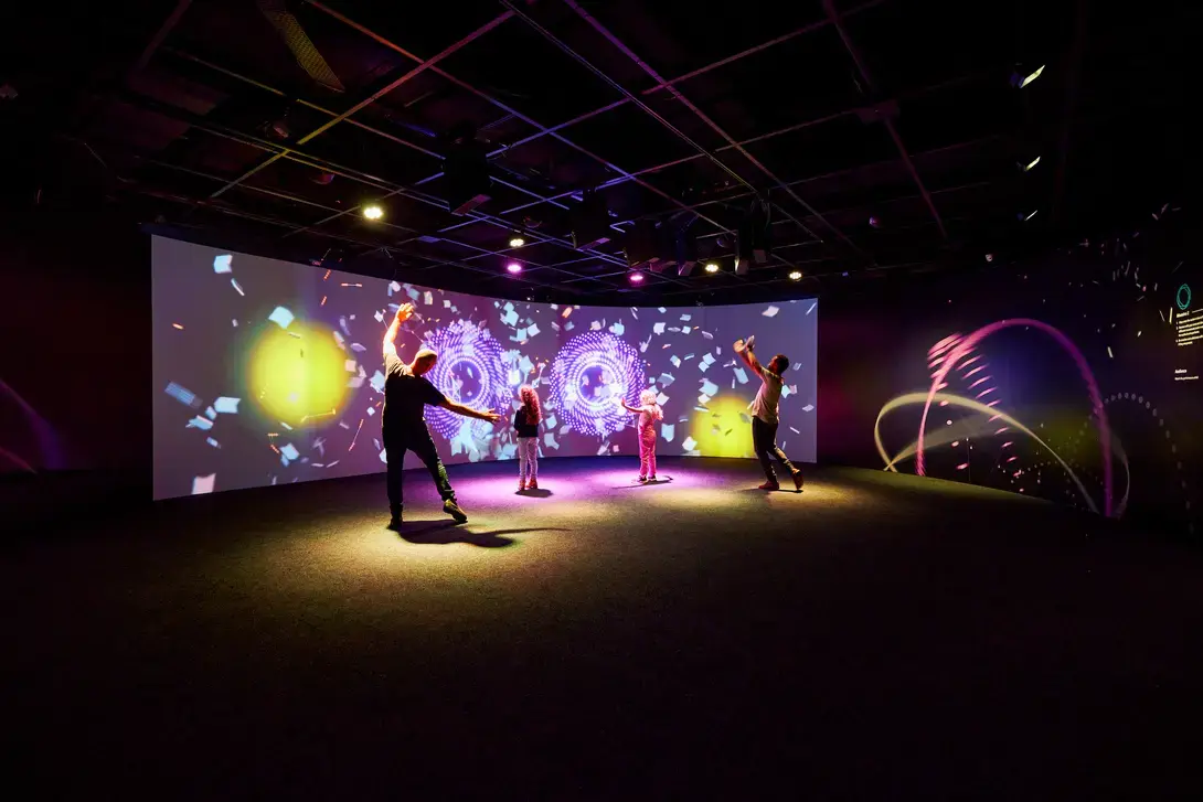 Photo of parents and children dancing in front of a large project at the Sydney Opera House