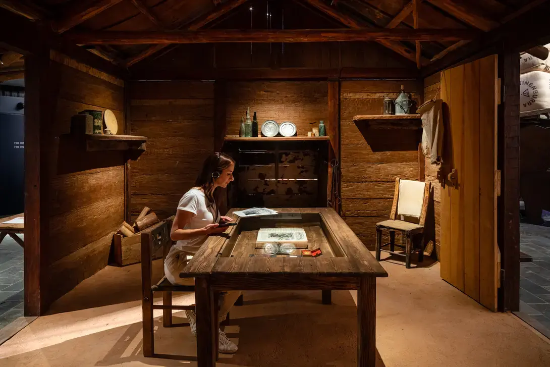 Image of a woman sitting at a table in an exhibit at the stockman's hall of fame.  