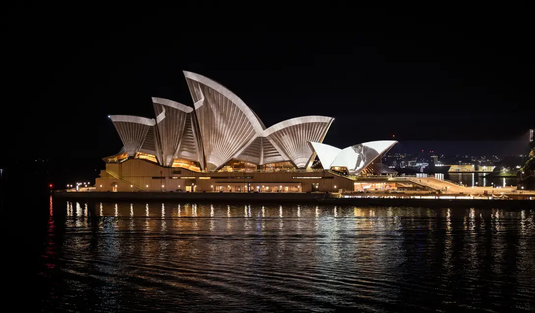 The Sydney Opera House at night, with projection mapping across its sails. Photography by Daniel Boud